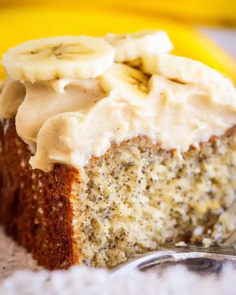Moist banana cake topped with spiced vanilla buttercream in a decorative setting.