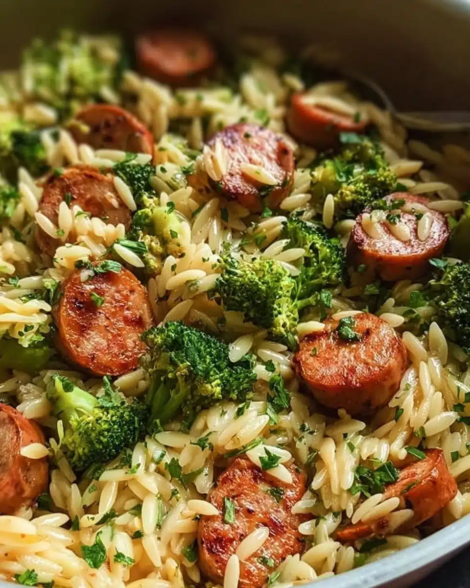 Chicken Sausage Broccoli Orzo Skillet in a skillet garnished with herbs