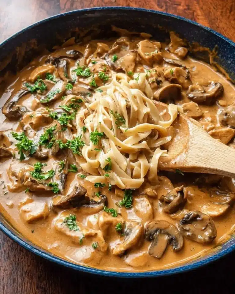 Delicious creamy Chicken Stroganoff served with noodles and garnished with parsley.
