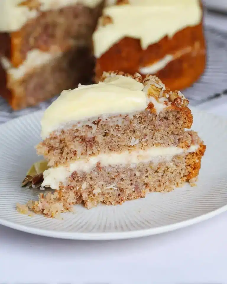 Delicious slice of Hummingbird Cake topped with cream cheese frosting.