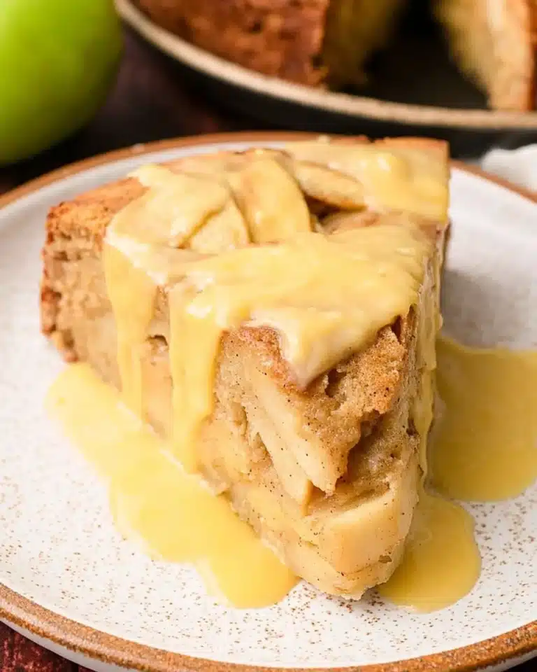 Delicious Irish Apple Cake served with creamy custard sauce on a plate.