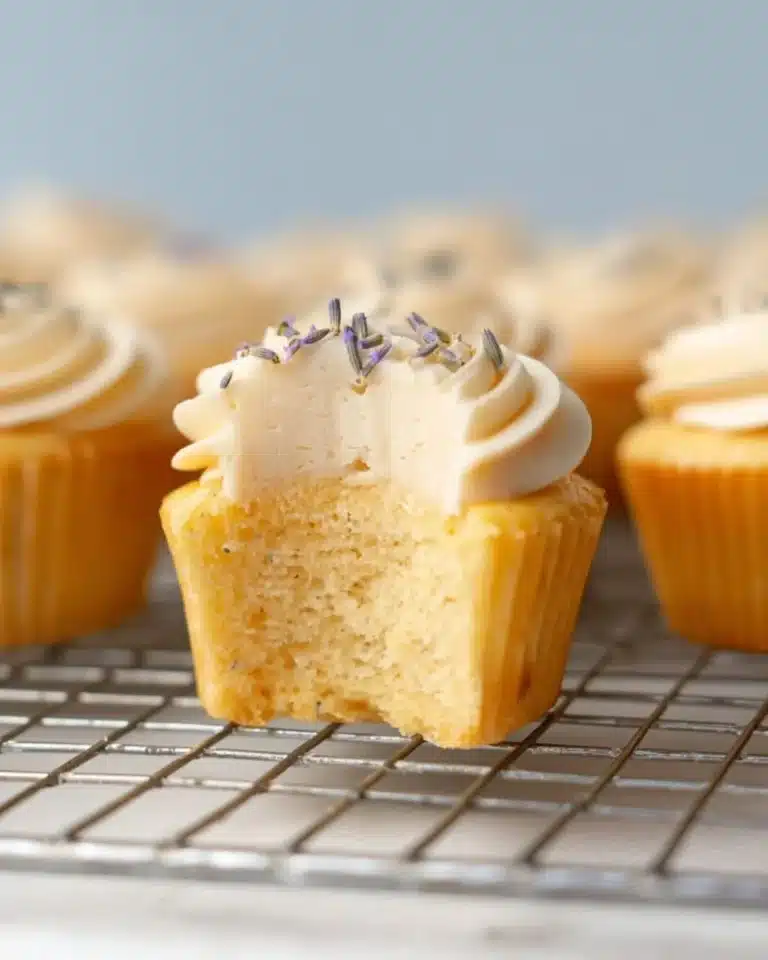 Lavender cupcakes topped with creamy frosting and edible flowers