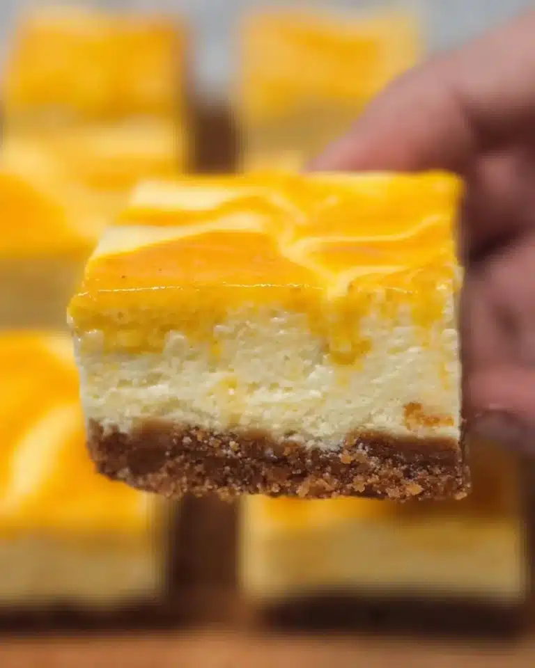 Delicious mango cheesecake bars topped with fresh mango slices