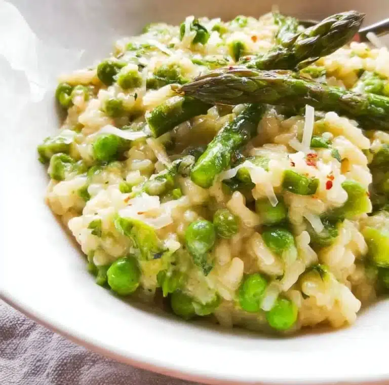 Bowl of creamy Asparagus and Pea Risotto topped with fresh herbs