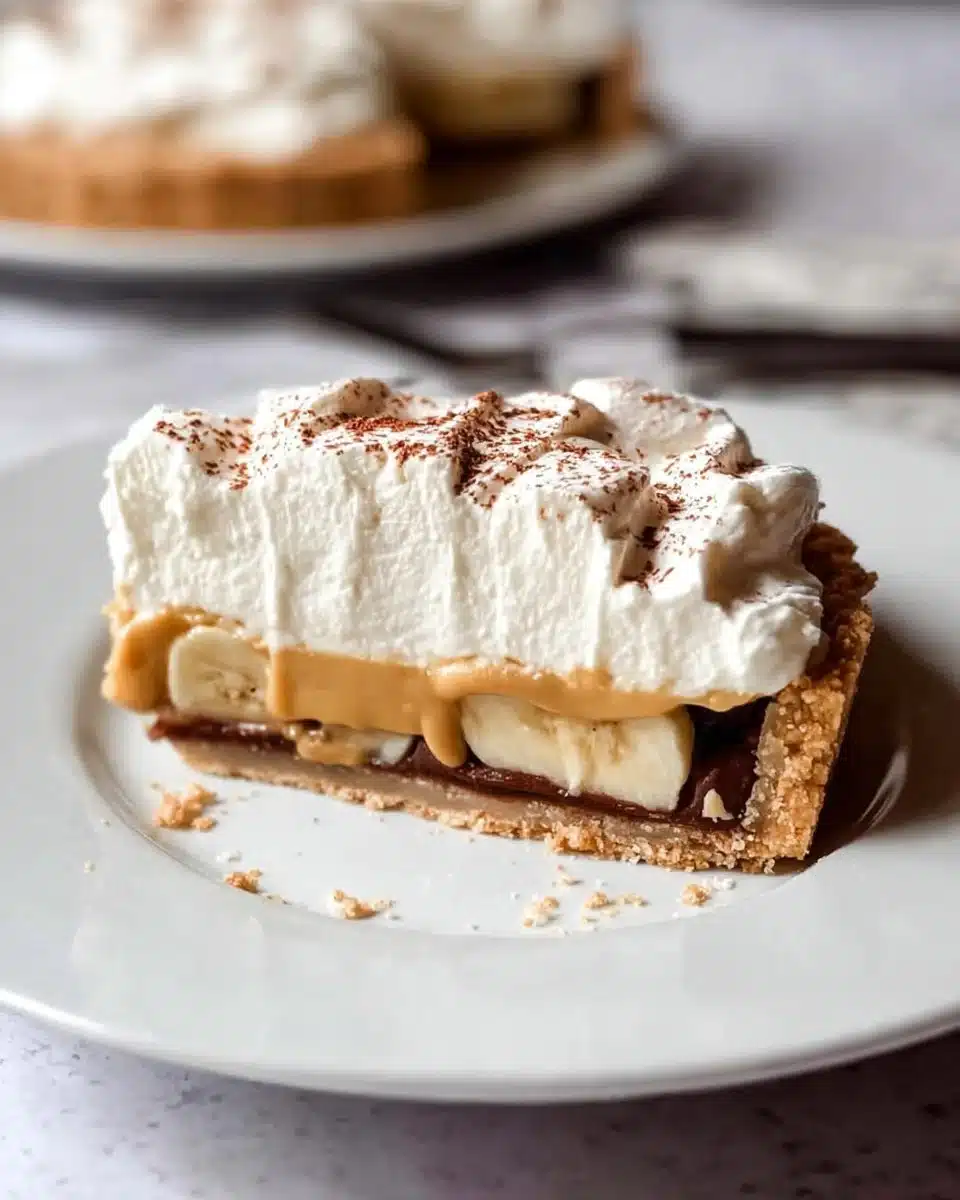 Delicious Banoffee Pie topped with banana slices and whipped cream.