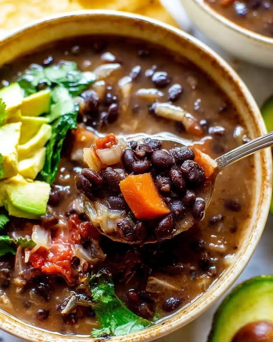 Bowl of delicious black bean soup garnished with herbs and spices.