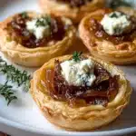 Caramelized onion and goat cheese tarts on a white plate