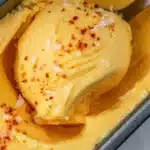 Chili Lime Mango Sorbet served in a bowl with lime slices and mint leaves.