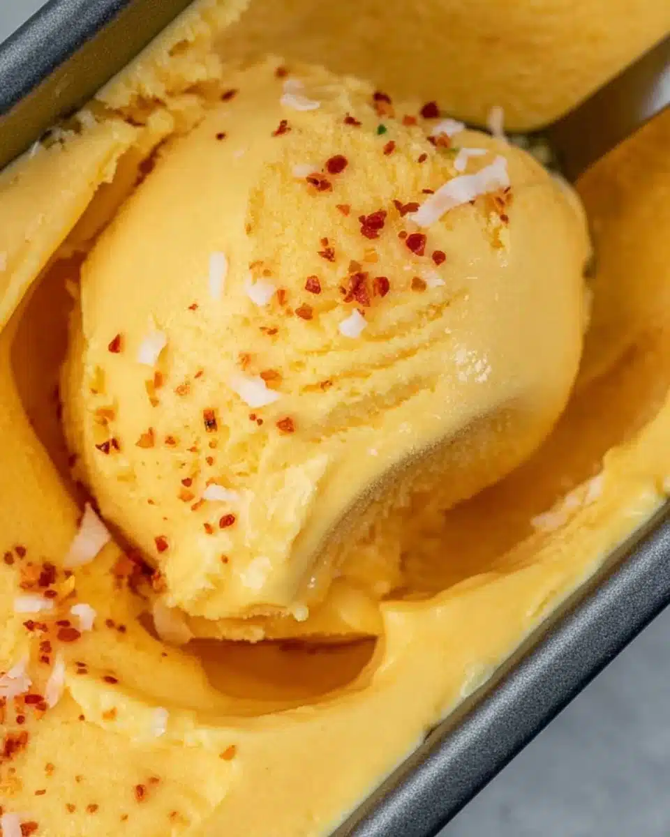 Chili Lime Mango Sorbet served in a bowl with lime slices and mint leaves.