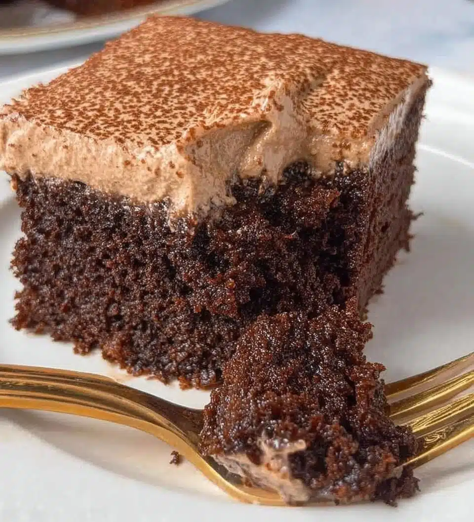 Delicious Chocolate Three Milks Cake topped with chocolate drizzle and cream