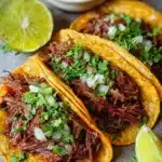 Delicious chuck roast tacos served with toppings and fresh ingredients.