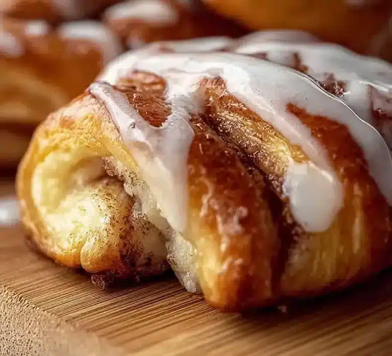 Cinnamon roll crescents freshly baked, golden brown and dripping with icing.