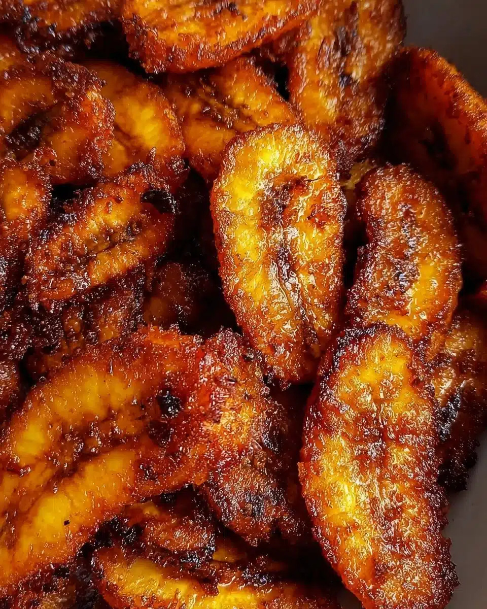 Fried sweet plantains served with a garnish of fresh herbs.
