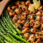 Delicious Garlic Butter Chicken Bites with fresh asparagus on a plate
