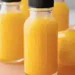 A refreshing ginger shot served in a small glass on a wooden background.