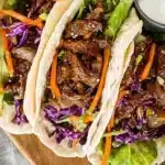Korean BBQ beef tacos topped with fresh vegetables and sauces
