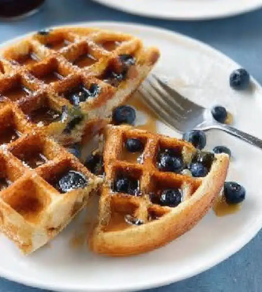 Plate of delicious lemon blueberry waffles topped with fresh berries
