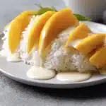 Delicious Mango Sticky Rice topped with ripe mango slices and coconut sauce