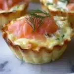 Mini smoked salmon quiches served on a platter for a delicious appetizer.