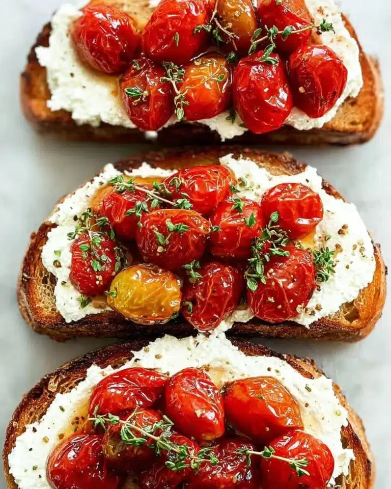 Ricotta toast crostini topped with roasted tomatoes on a white plate
