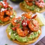 Shrimp tostadas topped with guacamole and fresh ingredients