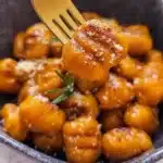 A serving of sweet potato gnocchi topped with sage and parmesan cheese