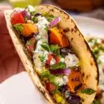 Delicious sweet potato tacos topped with fresh ingredients and served on a plate