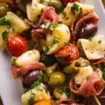 Colorful antipasto skewers with olives, cheese, and vegetables on a wooden platter