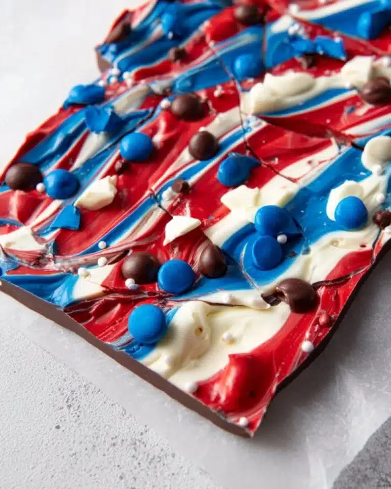 Homemade chocolate bark with nuts and dried fruits on a wooden board.