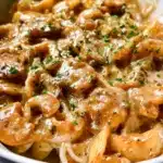 A plate of delicious Onion Pasta garnished with fresh herbs.
