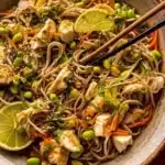Soba noodles and chicken bowl garnished with vegetables