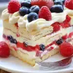 Delicious Berry Icebox Cake topped with fresh berries and whipped cream