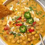 Delicious bowl of chickpea chili topped with herbs and spices.
