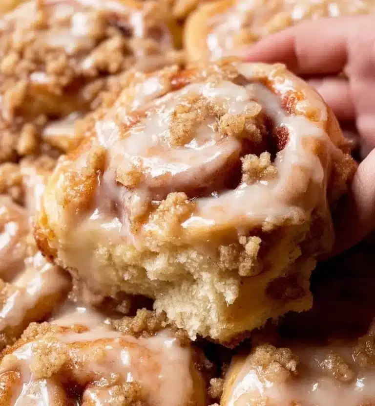 Peach cobbler cinnamon rolls topped with icing and fresh peaches