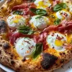 Prosciutto and honey burrata pizza topped with fresh herbs and a drizzle of honey