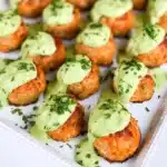 Delicious salmon meatballs served with creamy avocado sauce on a plate.