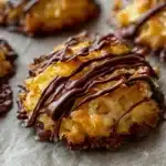Delicious Samoa Cookies topped with chocolate and caramel, garnished with coconut.