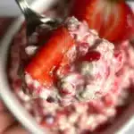 Fresh strawberries and cream mixed with overnight oats in a jar