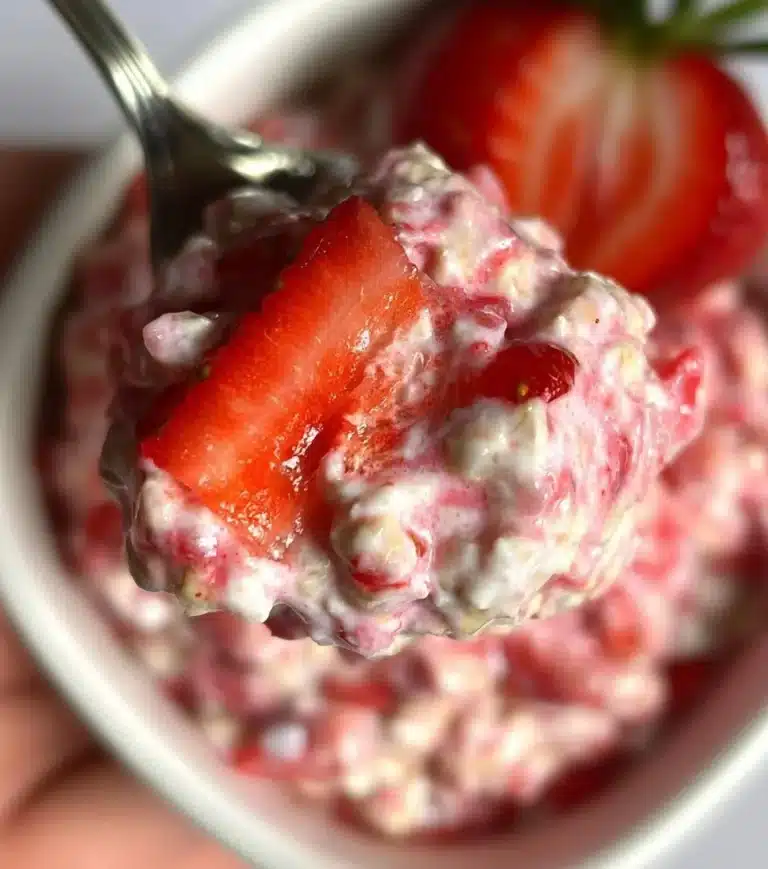 Fresh strawberries and cream mixed with overnight oats in a jar