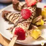 Colorful banana split kabobs with fruits and ice cream on skewers