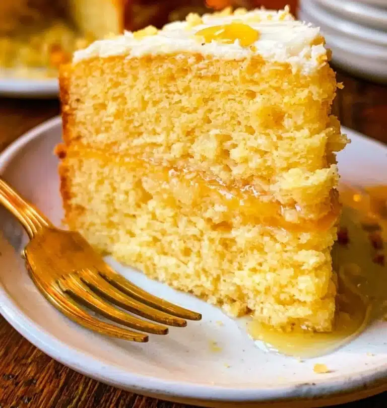 A delicious slice of cornbread cake on a plate with a fork.