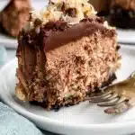Delicious slice of German Chocolate Cheesecake topped with coconut and pecans
