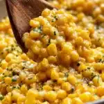 Delicious honey butter corn dish served in a bowl, garnished with herbs.
