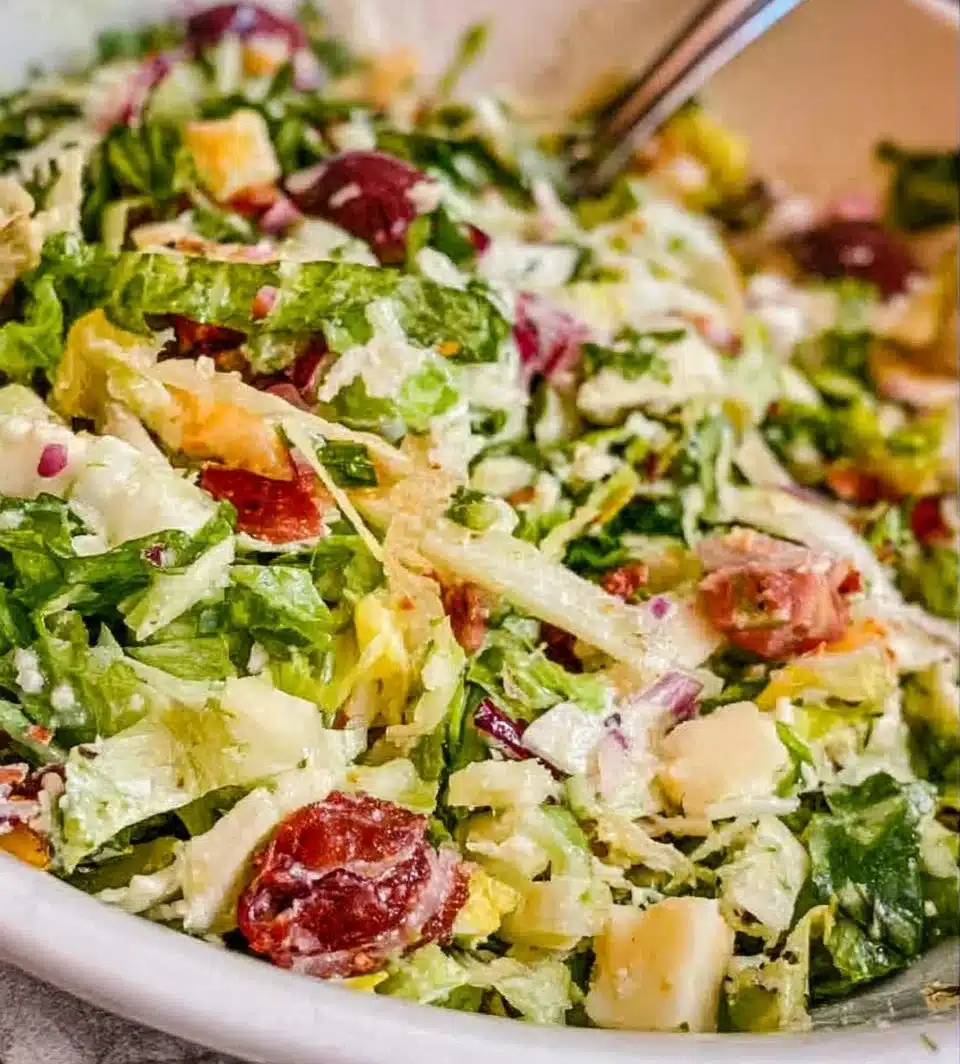 A vibrant La Scala Salad with fresh vegetables and dressing served in a bowl.