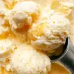 Delicious homemade peach ice cream in a bowl with fresh peaches