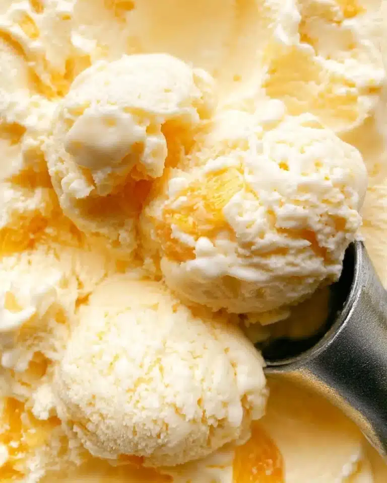 Delicious homemade peach ice cream in a bowl with fresh peaches
