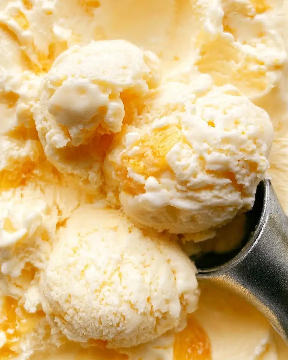 Delicious homemade peach ice cream in a bowl with fresh peaches