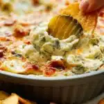 Bowl of creamy pickle dip served with chips and veggies