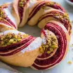 Raspberry and Pistachio Wreath dessert with vibrant colors and intricate design.