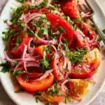 Delicious and colorful tomato salad with fresh ingredients and herbs